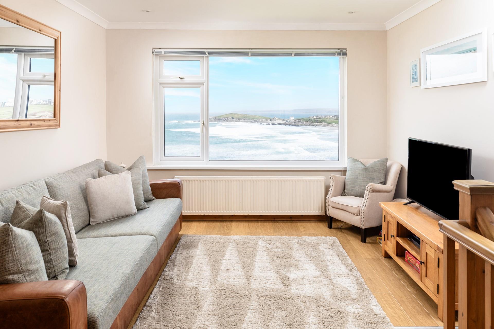 The cosy sitting room offers a space to relax and watch the waves.