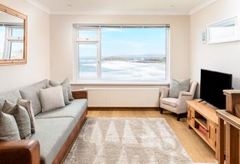 The cosy sitting room offers a space to relax and watch the waves.