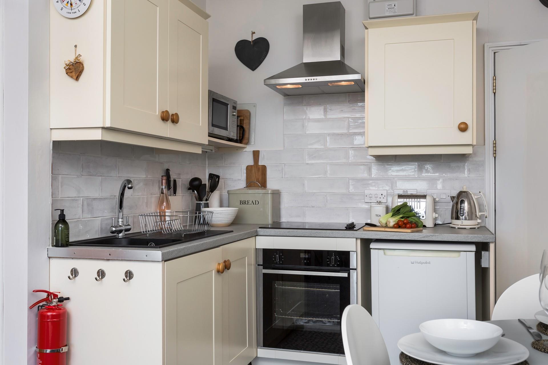 Although compact, the kitchen is fully equipped to prepare and cook meals.