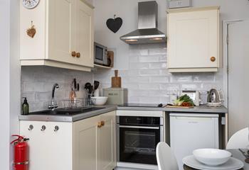 Although compact, the kitchen is fully equipped to prepare and cook meals.