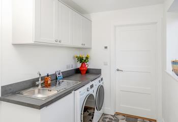 The utility room is equipped with a washing machine and tumble dryer.