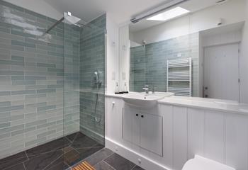 Step into the beautifully designed shower after a day of coastal exploration.