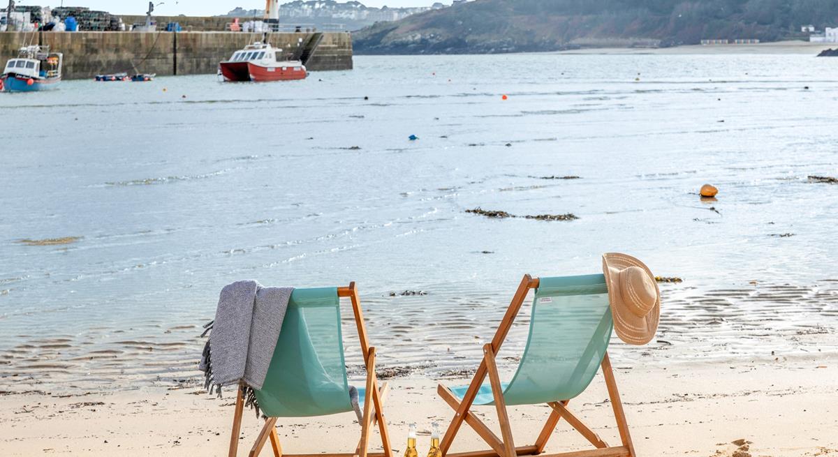 Sit on the beach in a deckchair in the summer sun.