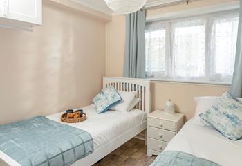 Bedroom 2 has twin beds and is decorated with pastel blues. 