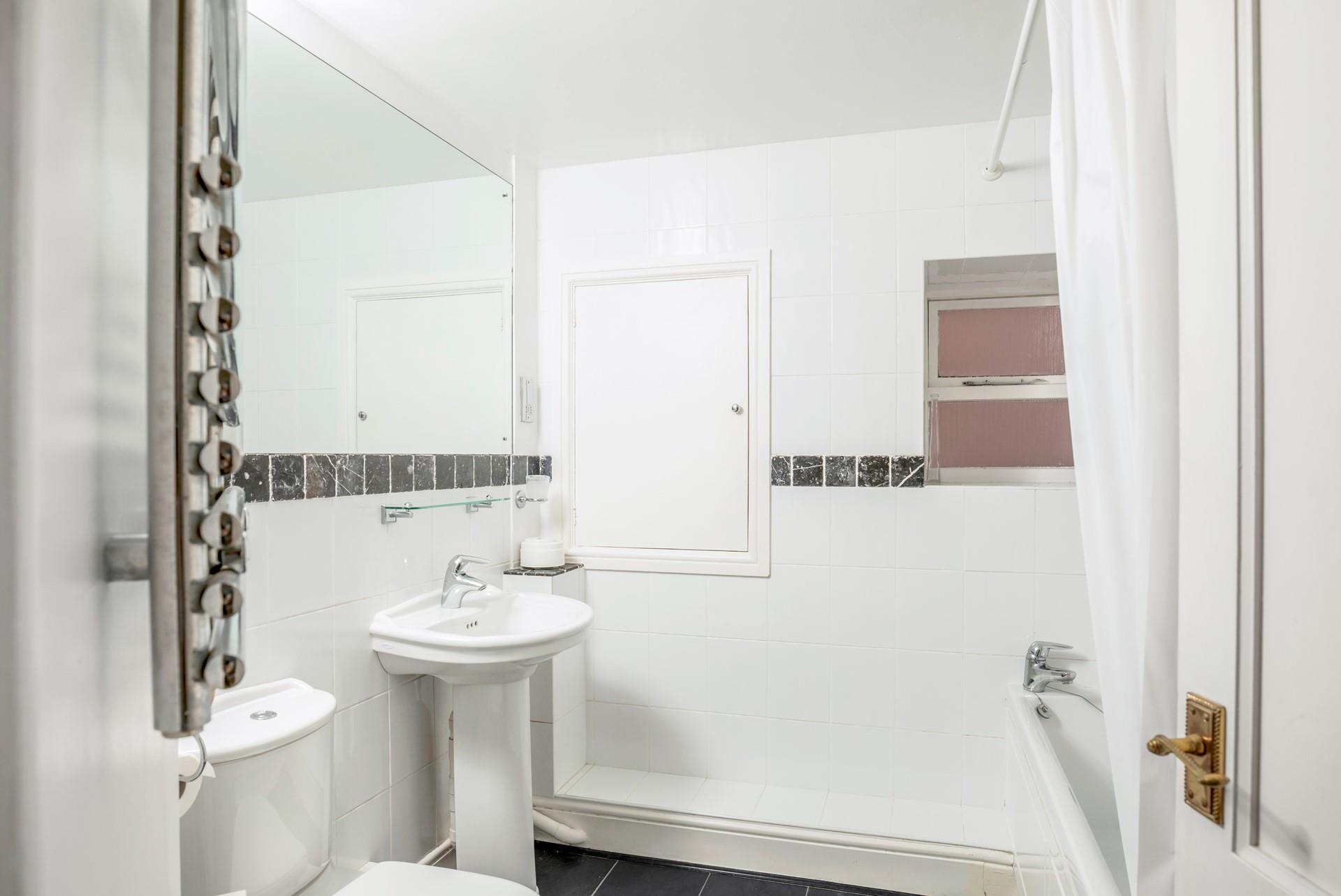 There is a bath with a shower over, perfect for washing off sandy toes after beach days.