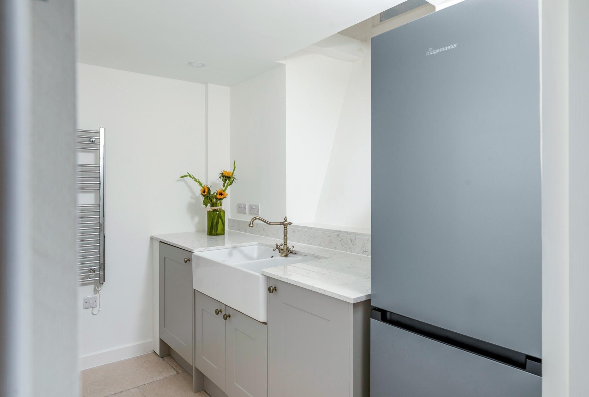 The utility area has a sink and fridge freezer.