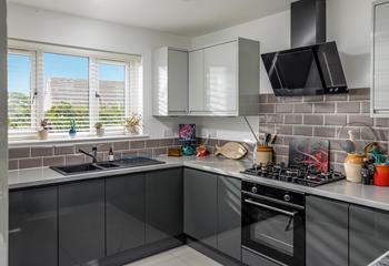 The kitchen is modern and sleek, a dream to cook in!