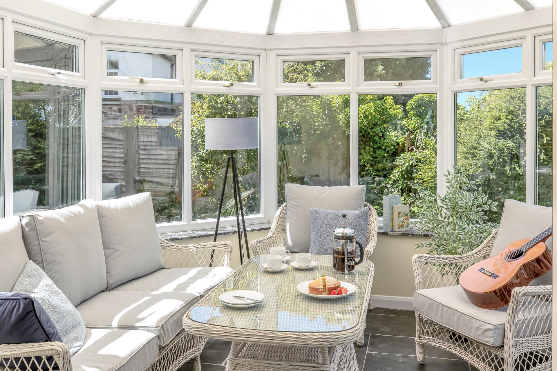 The conservatory is an additional space to relax and enjoy a cup of coffee.