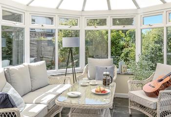 The conservatory is an additional space to relax and enjoy a cup of coffee.