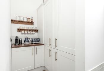 The fridge, tea, and coffee station are in the utility room off the kitchen.