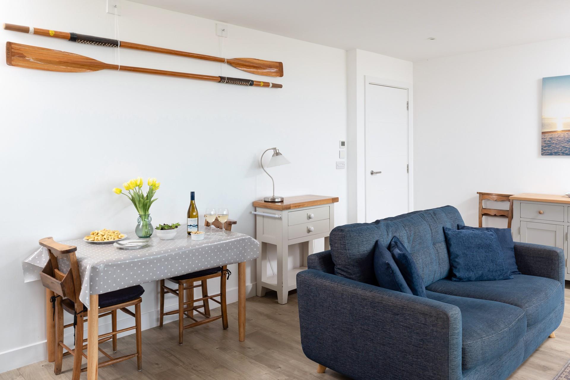 The living area features comfortable sofas and a dining table for two.