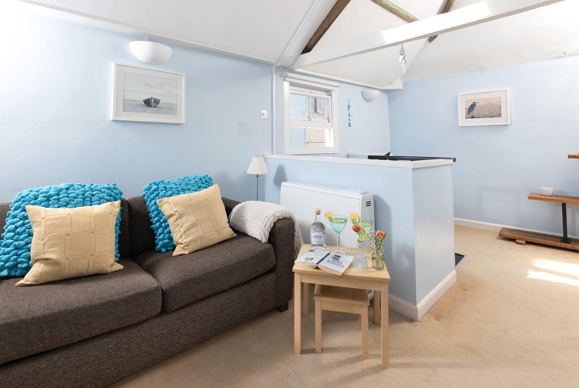 The cosy living area is perfect for relaxing by the sea.
