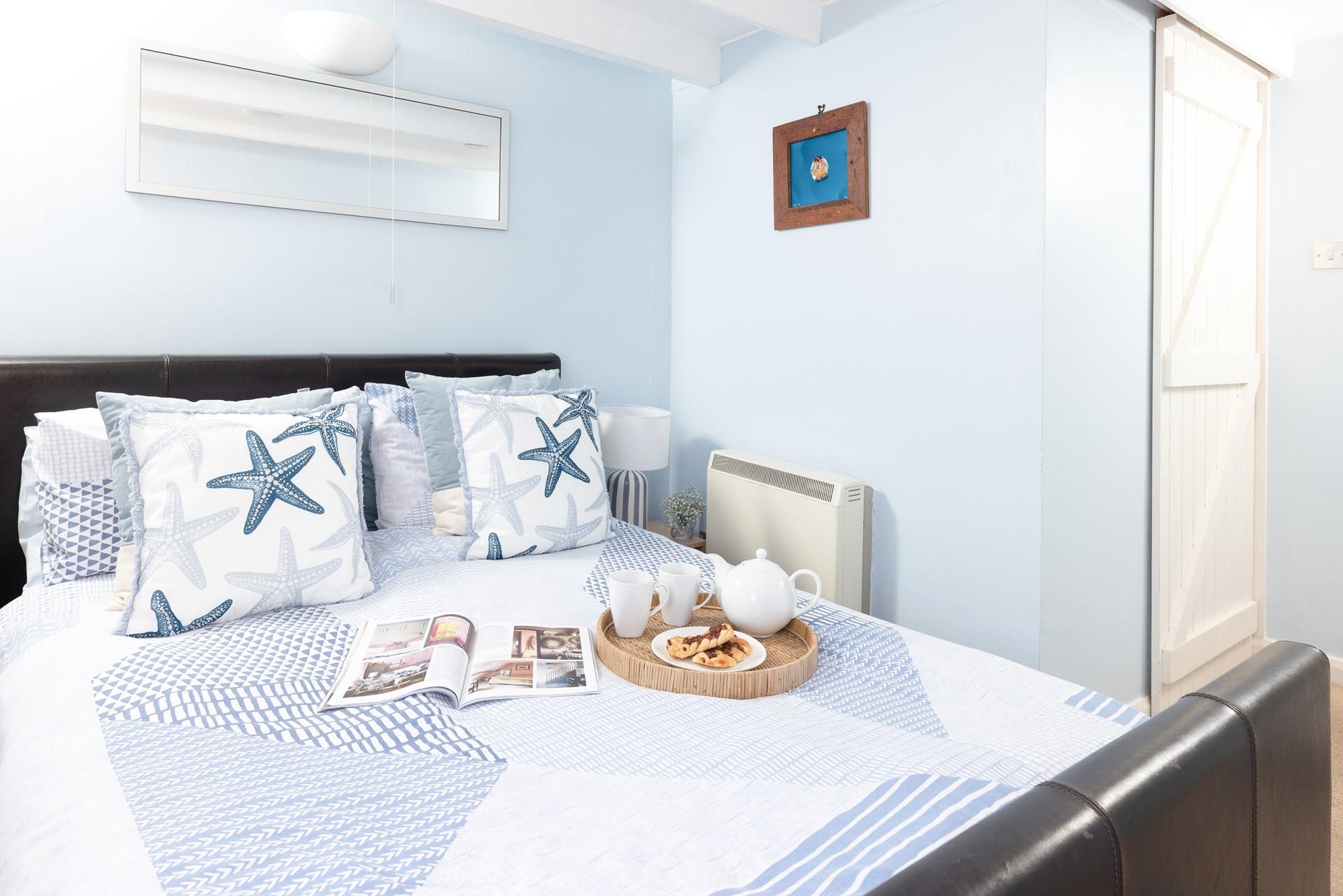 Coastal decor in the bedroom reflects the seaside location of the cottage.