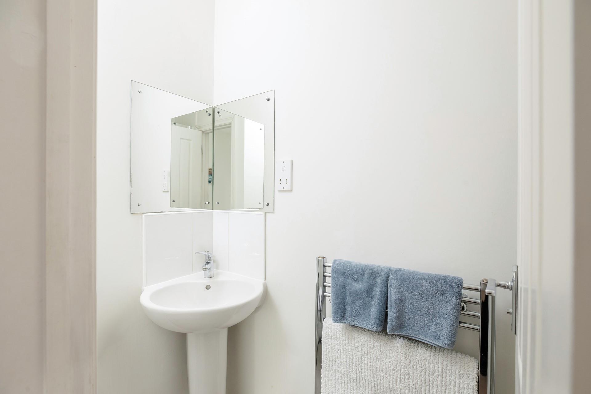 The compact shower room has a heated towel rail for warming fluffy towels.