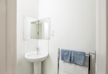 The compact shower room has a heated towel rail for warming fluffy towels.