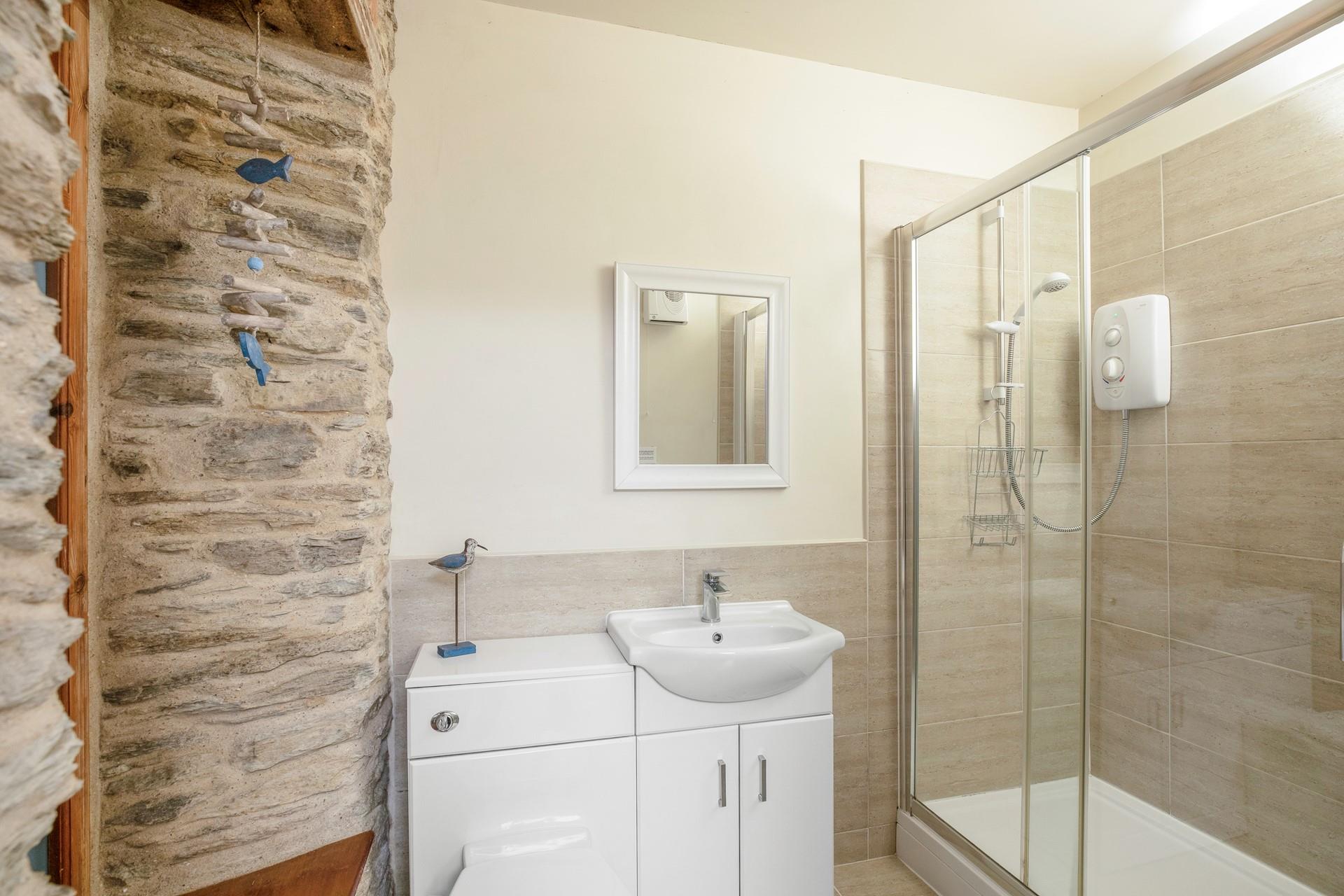 The en suite is bright and stylish with a spacious walk-in shower.