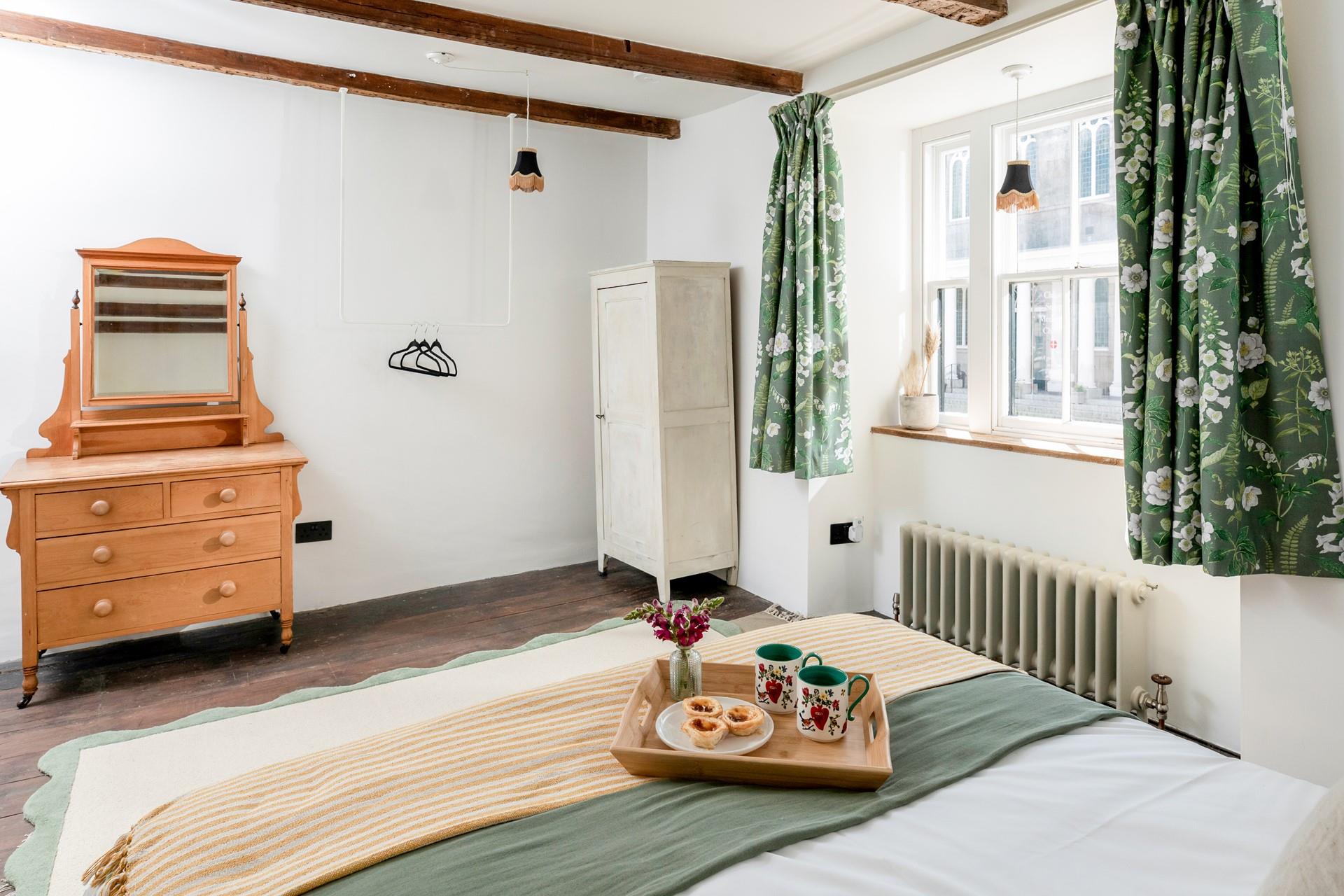 The bedroom is spacious with traditional features such as the beams and furniture.