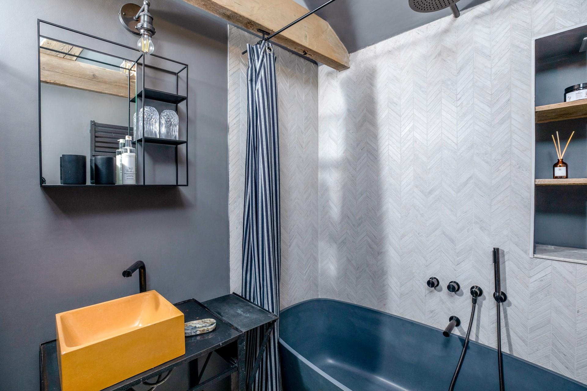 The en suite is beautifully finished with a freestanding bath and a shower.