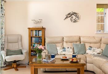 The sitting room has a seaside theme and is decorated with lovely blue-toned cushions.