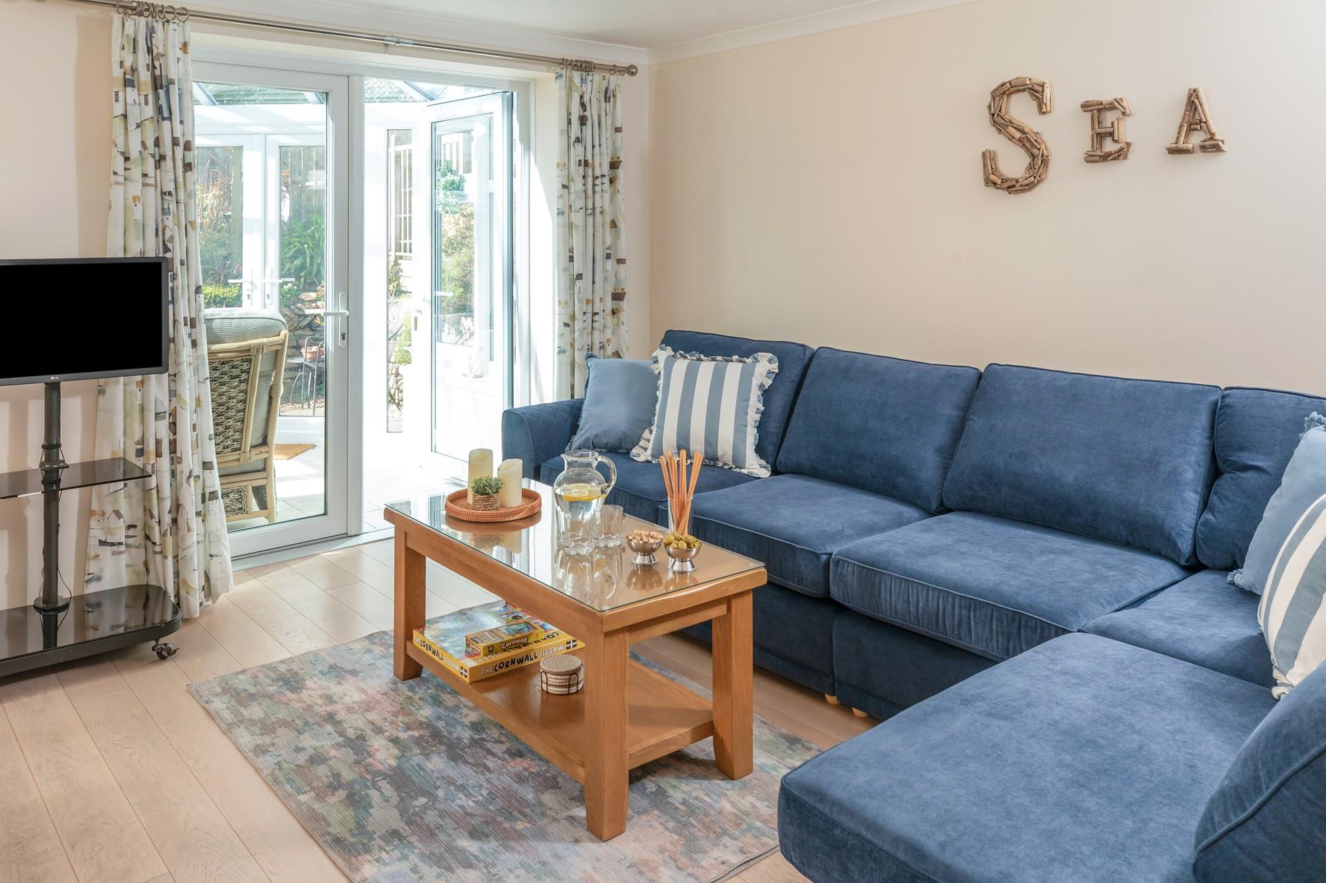 The sitting room has a seaside theme and is decorated with lovely blue-toned cushions.
