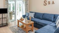The sitting room has a seaside theme and is decorated with lovely blue-toned cushions.