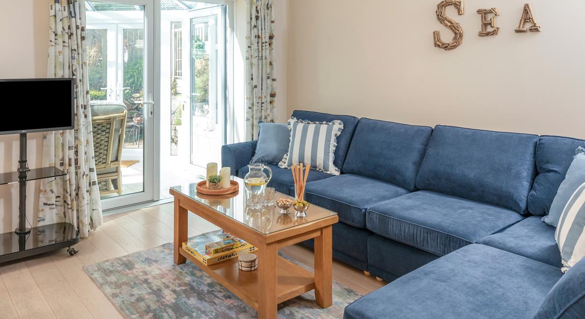 The sitting room has a seaside theme and is decorated with lovely blue-toned cushions.