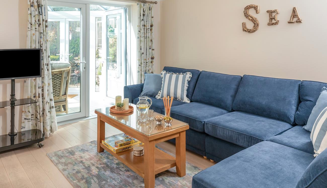The sitting room has a seaside theme and is decorated with lovely blue-toned cushions.