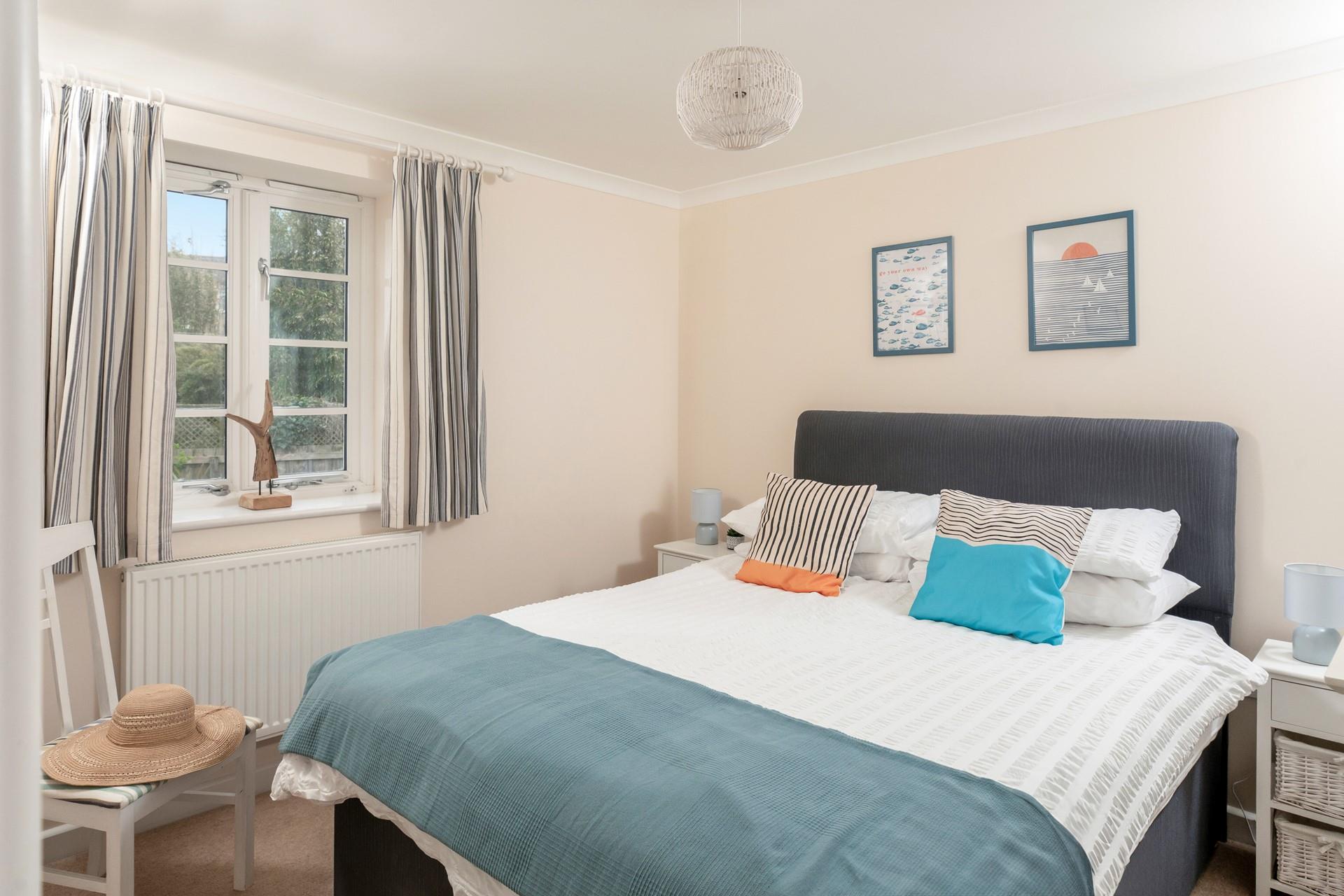 Bedroom 1 has a spacious double bed and is decorated with ocean blue hues.