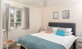 Bedroom 1 has a spacious double bed and is decorated with ocean blue hues. - Thumbnail Image
