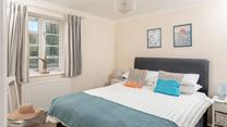 Bedroom 1 has a spacious double bed and is decorated with ocean blue hues.