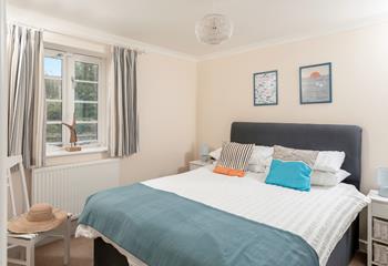 Bedroom 1 has a spacious double bed and is decorated with ocean blue hues.