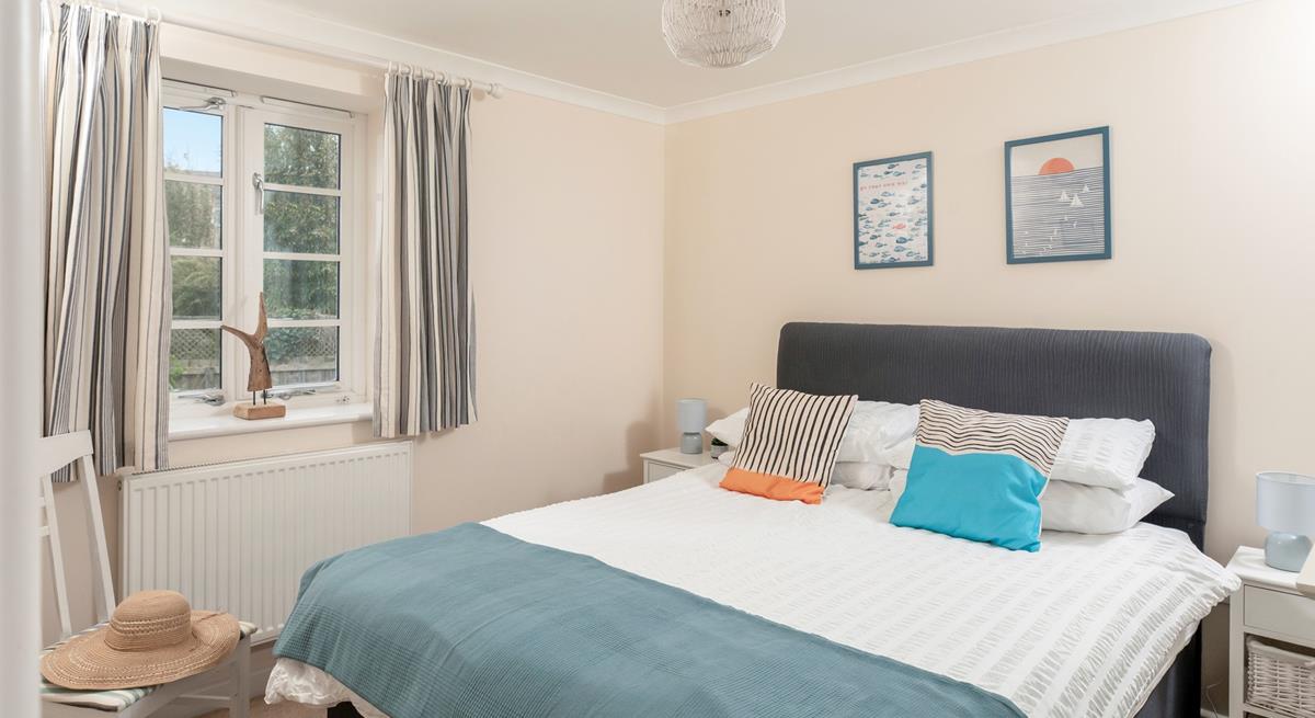 Bedroom 1 has a spacious double bed and is decorated with ocean blue hues.