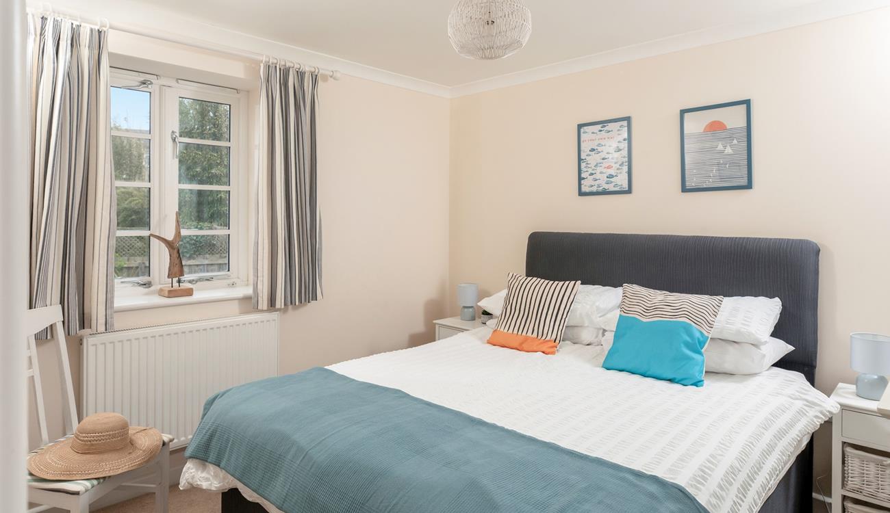 Bedroom 1 has a spacious double bed and is decorated with ocean blue hues.