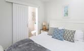 The bedroom is decorated with calming seaside blues. - Thumbnail Image