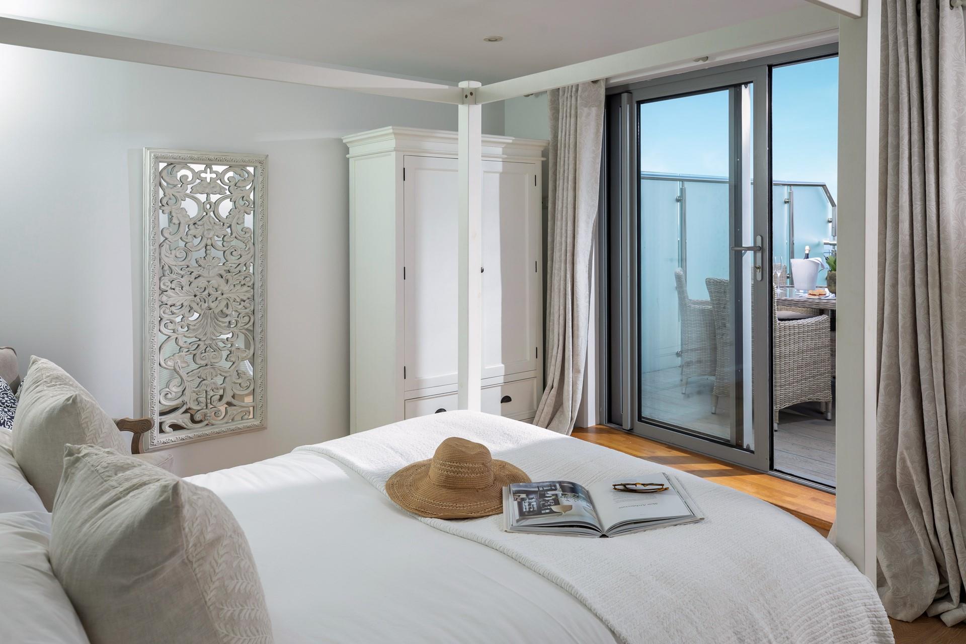 The bedroom has a luxurious four-poster bed and balcony with sea views.