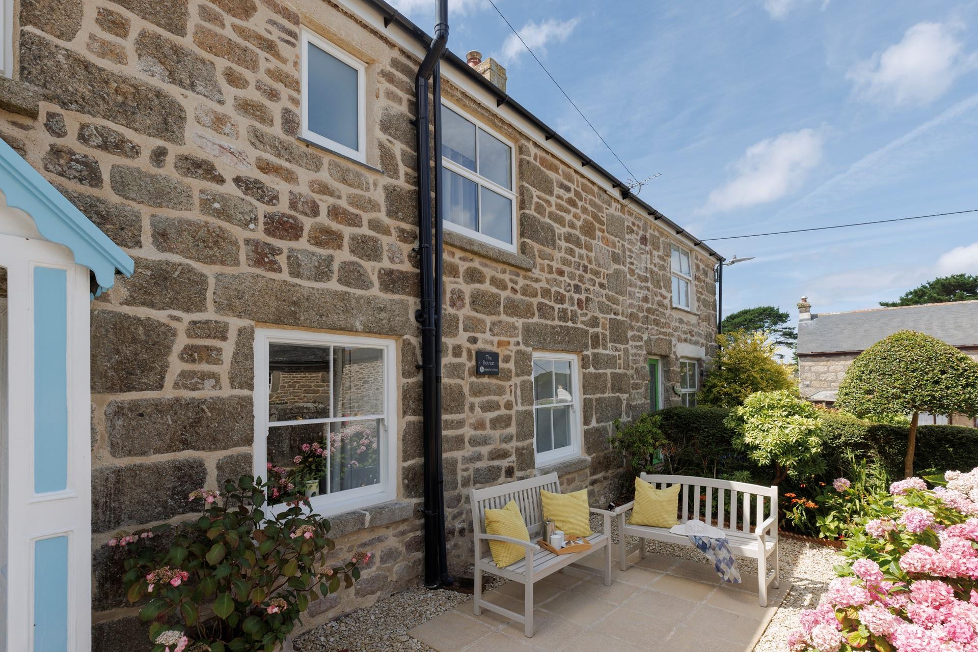 The front garden blooms in the sunshine, the perfect spot to unwind.