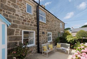 The front garden blooms in the sunshine, the perfect spot to unwind.