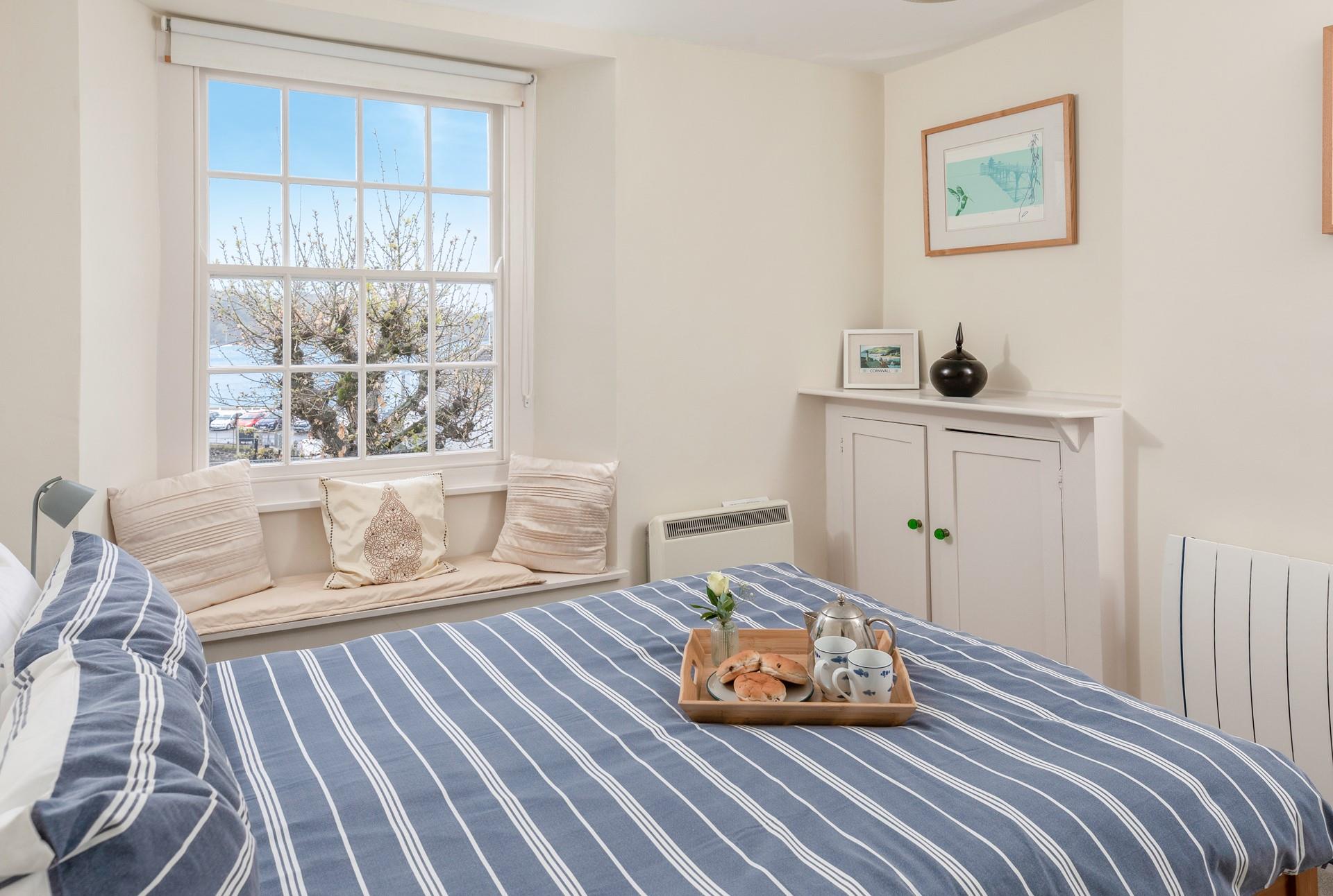 Bedroom 1 has sea views through the trees.
