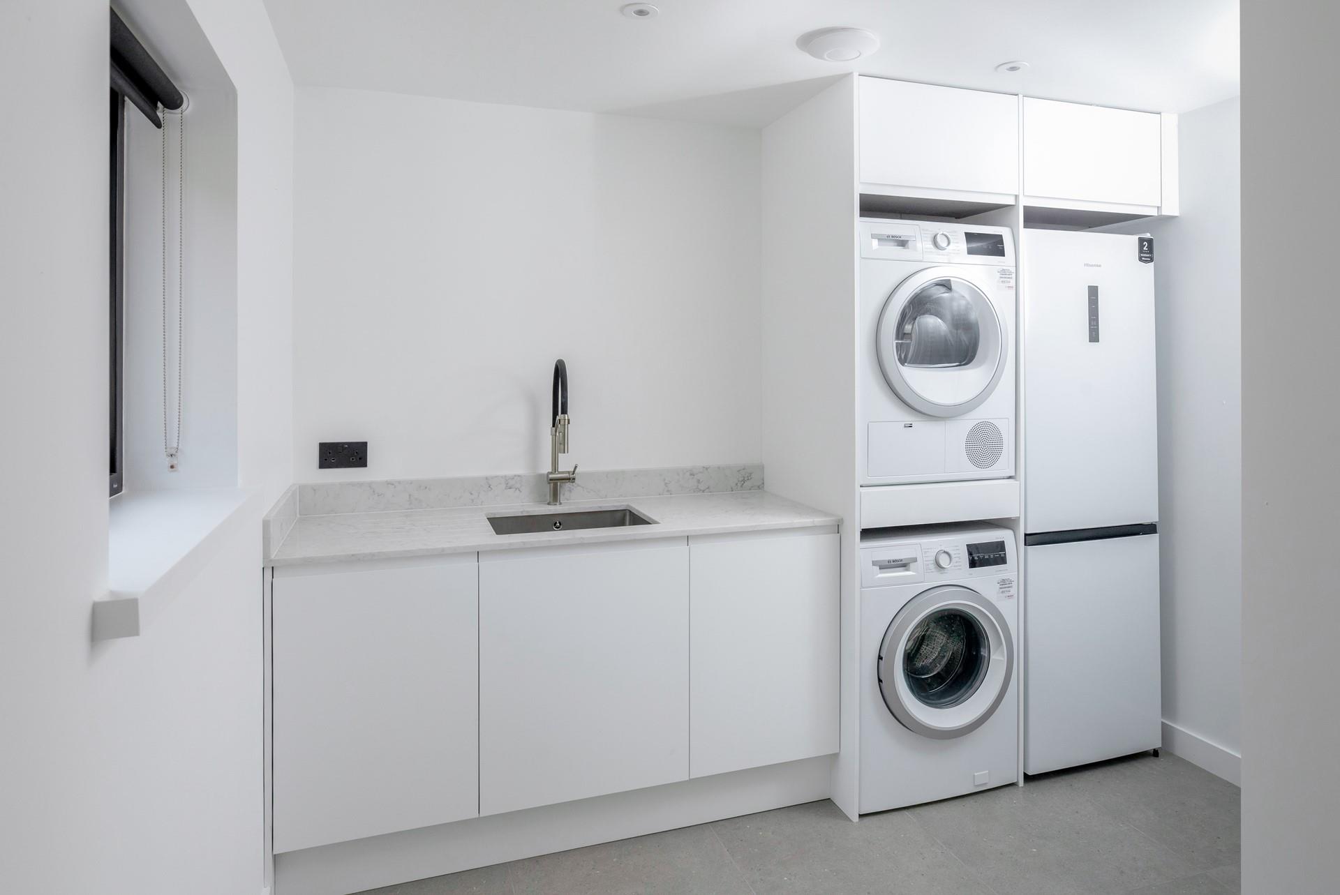 The utility room is a handy area with a washing machine and tumble dryer.