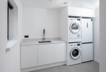 The utility room is a handy area with a washing machine and tumble dryer.