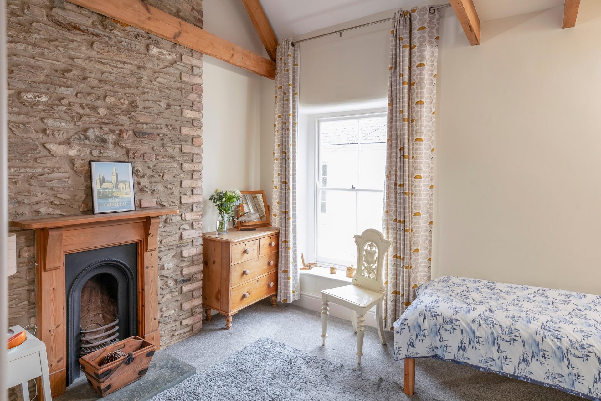 Bedroom 2 has twin beds and a feature fireplace.