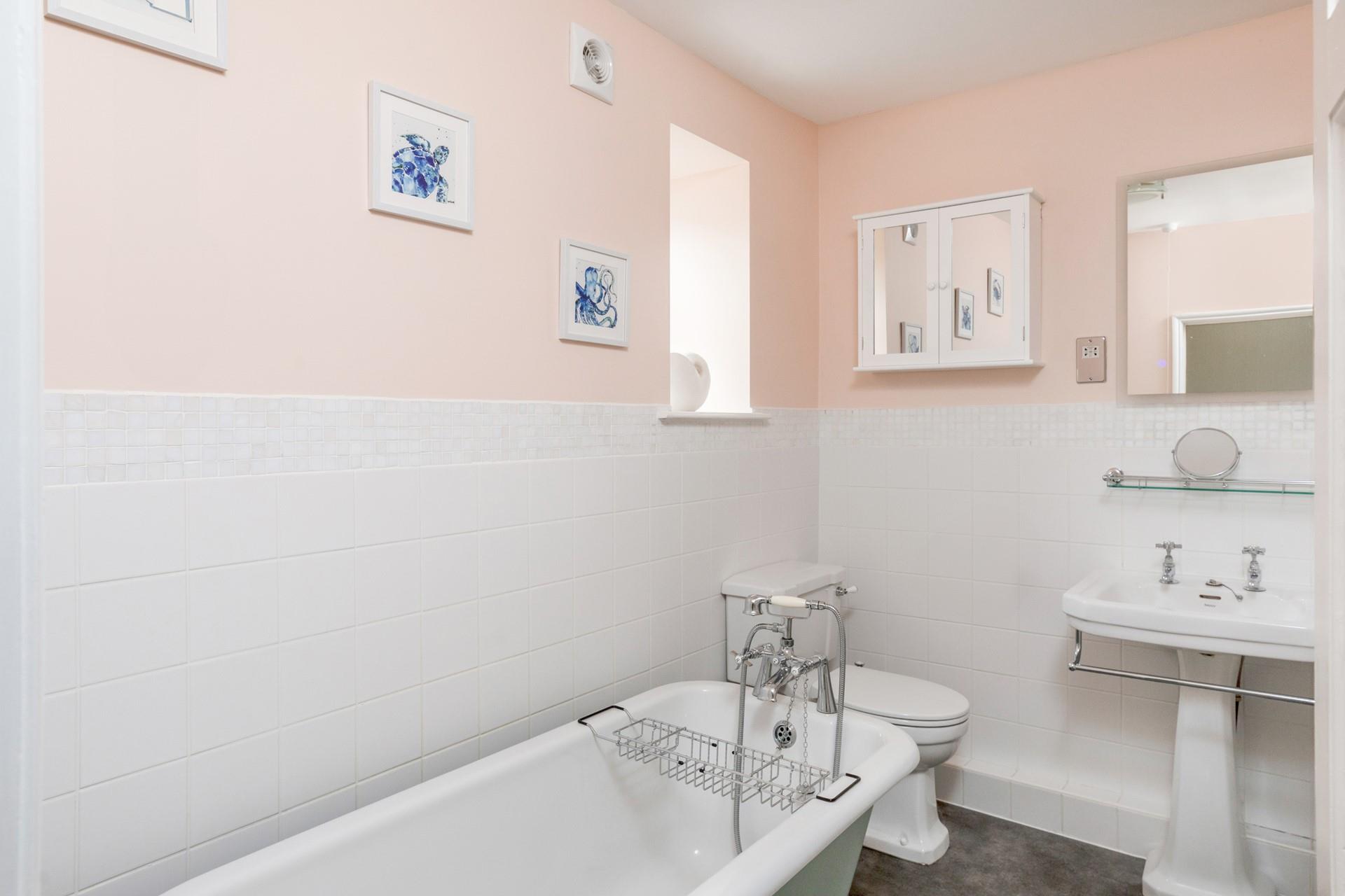 Unwind in the bubbles in the luxurious roll top bath.