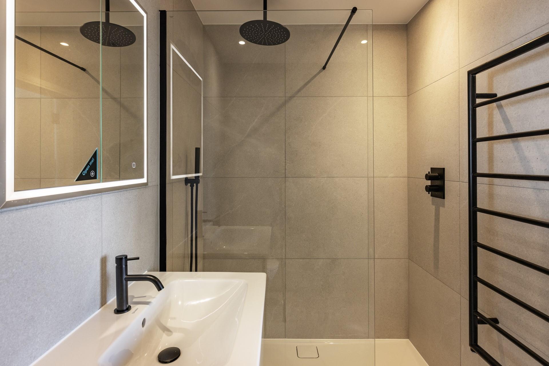 The sleek en suite offers a rainfall shower and an LED mirror.