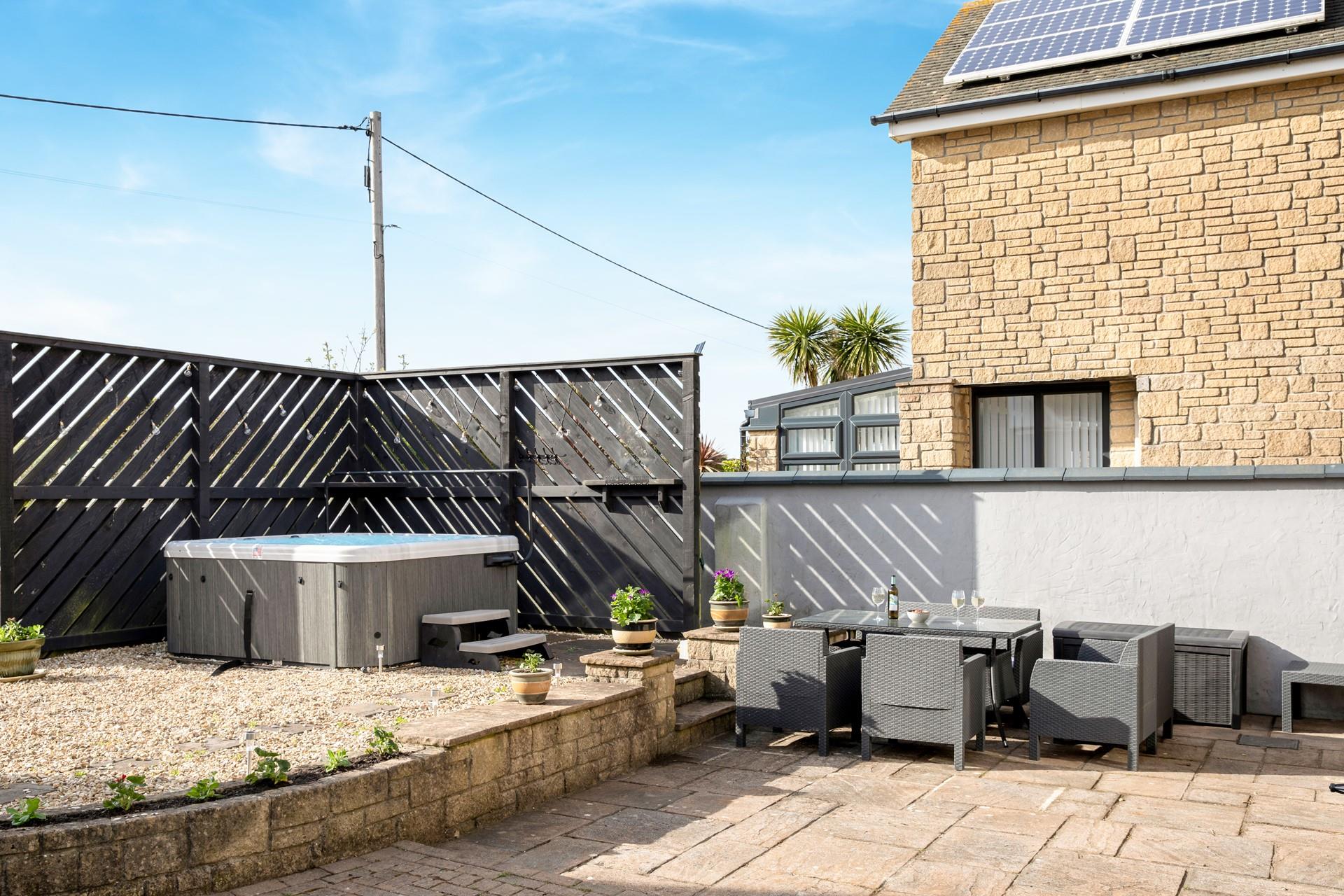 The back garden has a hot tub and dining area, perfect for al fresco evenings!