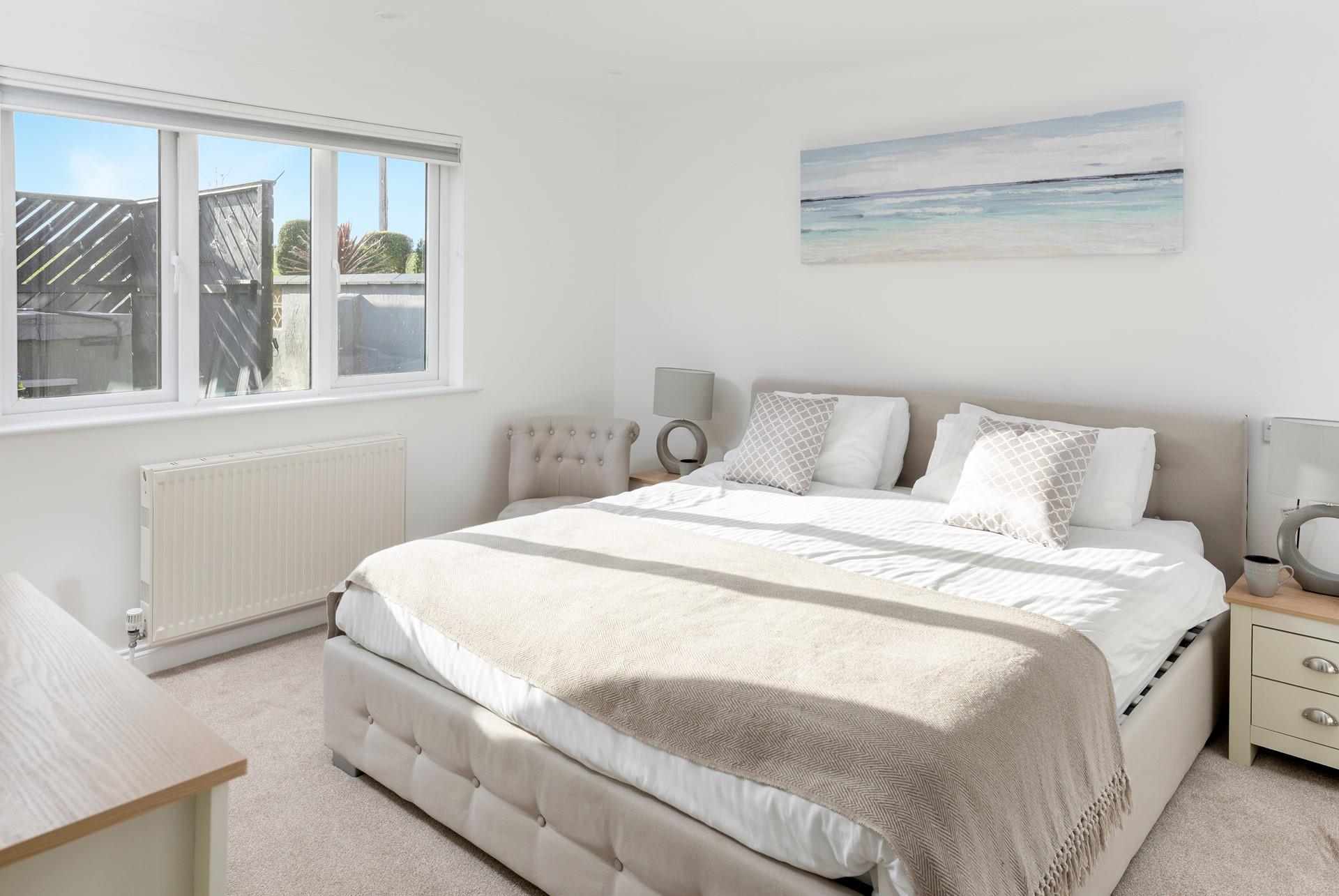 The master bedroom is tastefully decorated with calming tones.