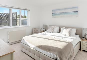 The master bedroom is tastefully decorated with calming tones.