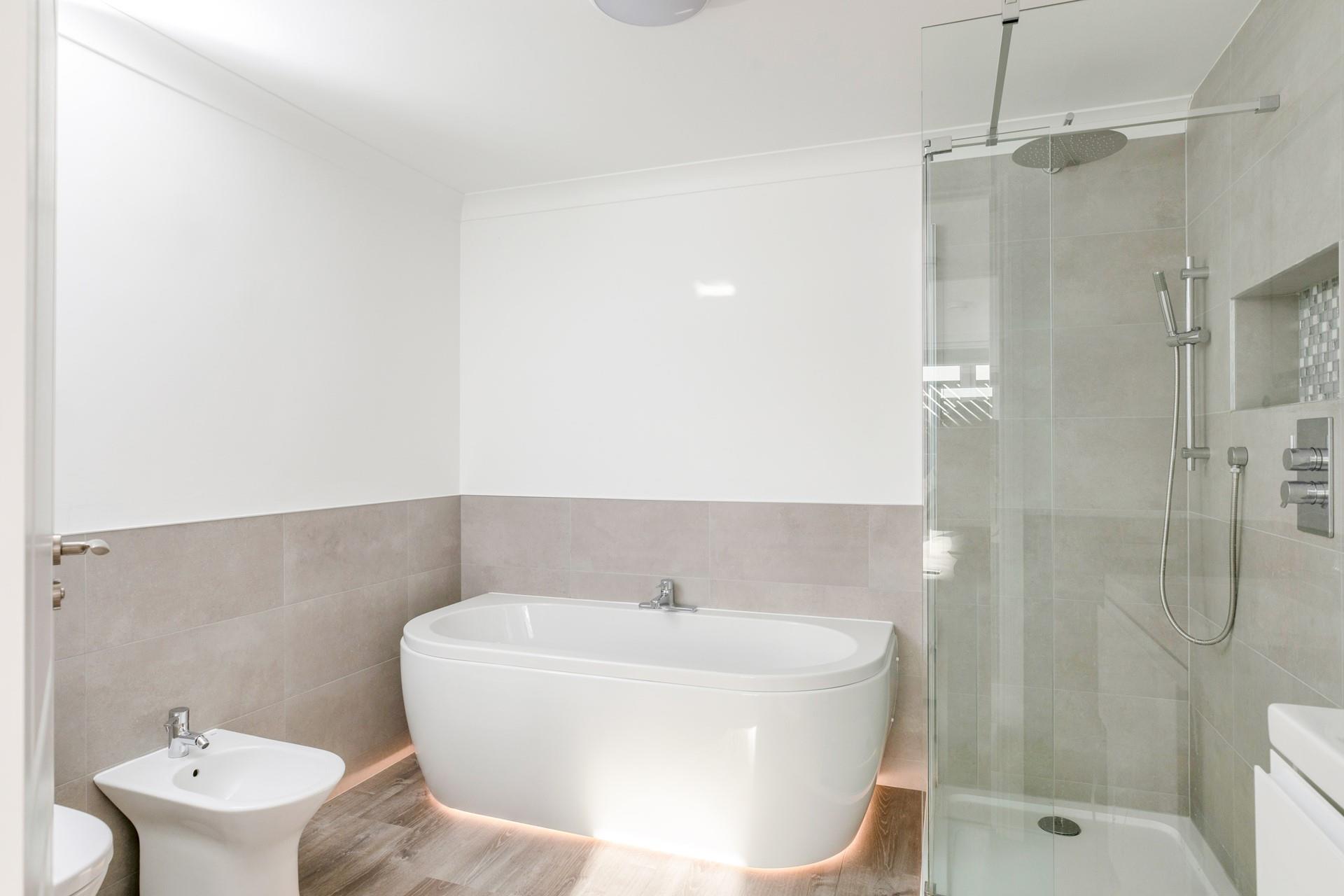 The en suite bathroom has a stylish free-standing bath and rainhead shower.