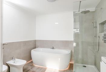 The en suite bathroom has a stylish free-standing bath and rainhead shower.