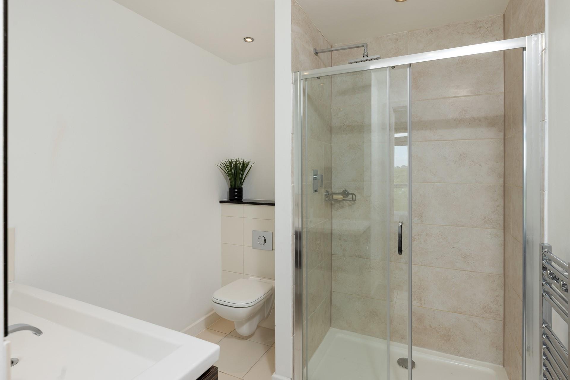 The en suite has a spacious rainfall shower.