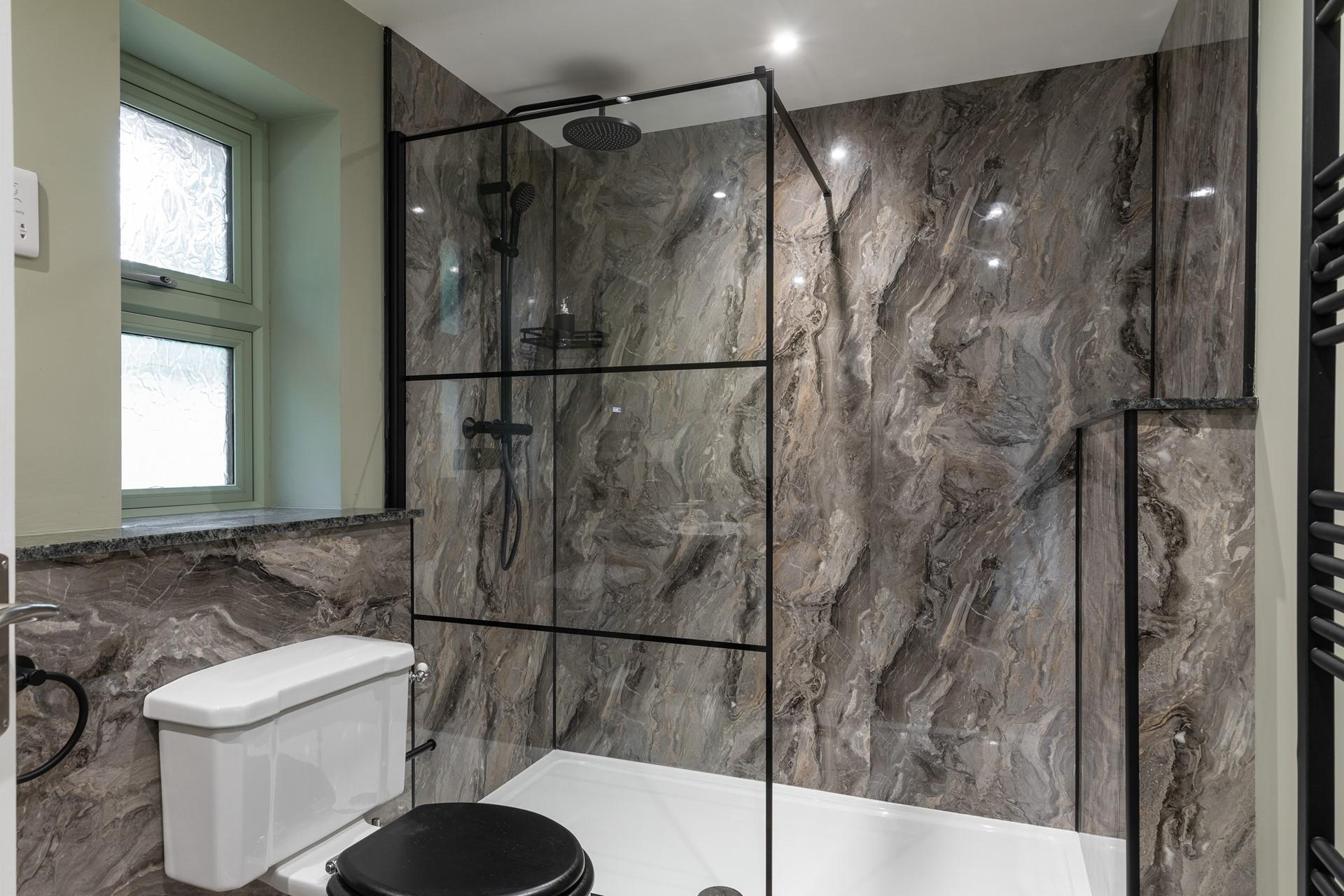 The bathroom has a large walk in shower with a rainfall head.